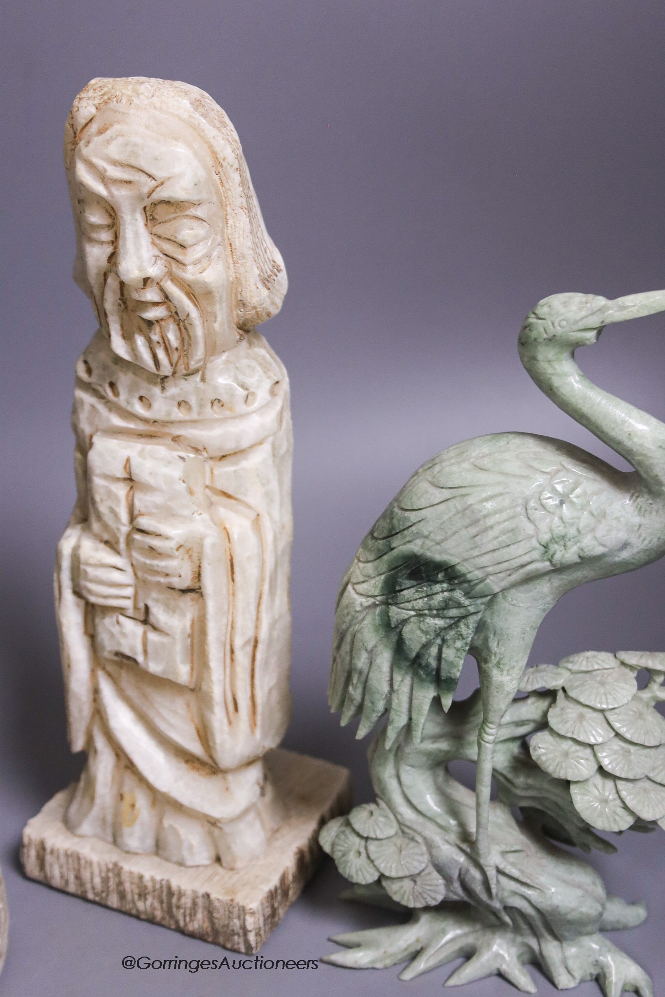 A large marble lion's paw, an alabaster monk, a soapstone crane and a white metal model of The Queen Mary ship